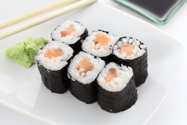 Sushi di salmone Maki con bacchette e salsa di soia in bianco