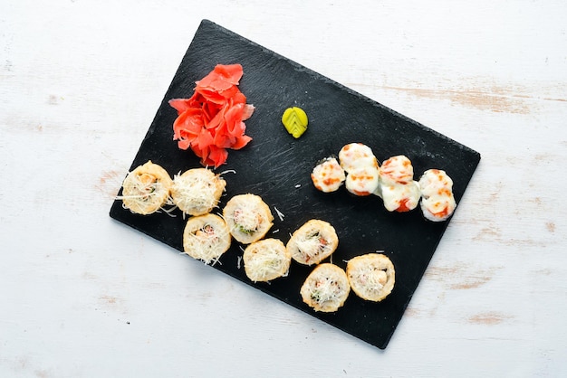 Sushi e maki rotoli su un piatto. Vista dall'alto. Spazio libero per il tuo testo. Su uno sfondo bianco.