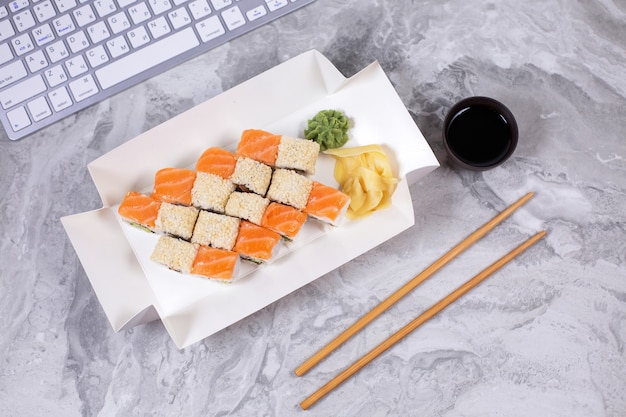 Sushi e panini assortiti vicino alla tastiera del computer.