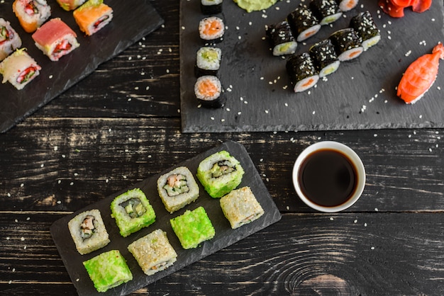 Sushi freschi e gustosi su sfondo scuro. Può essere usato come sfondo