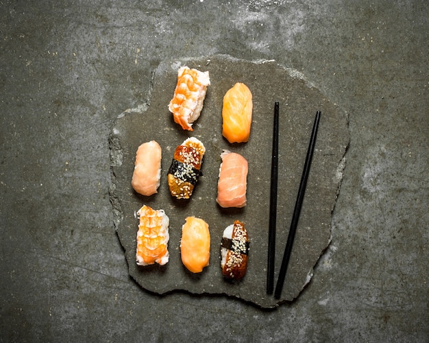 Sushi giapponese con salmone, gamberetti e anguilla. Sul tavolo di pietra.