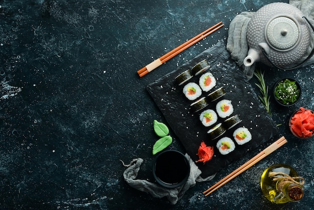 Sushi maki con salmone, avocado e nori Spazio libero per il testo Cucina tradizionale giapponese Vista dall'alto Stile rustico