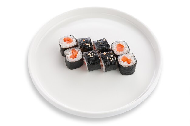 Sushi Maki con salmone e semi di sesamo. Su un piatto di ceramica bianca. Sfondo bianco. Isolato.