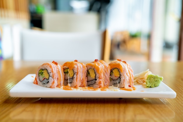 sushi roll al salmone con salsa in cima