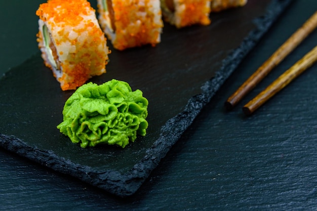 Sushi roll philadelphia con salmone, riso, formaggio, cetriolo, avocado e caviale su una tavola di ardesia. cibo giapponese
