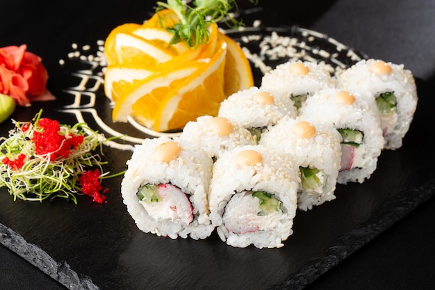 Sushi Rolls con avocado, cetriolo, cipolla verde e carota dentro sul nero