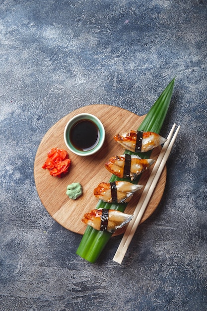 Sushi Sashimi impostato su tavola di legno sfondo di pietra vista superiore