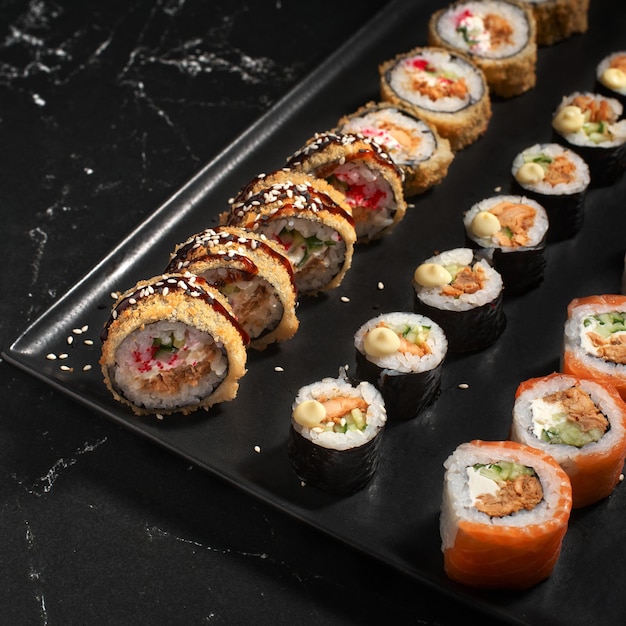 Sushi set Rotolo con ingredienti freschi su sfondo di pietra Vista dall'alto