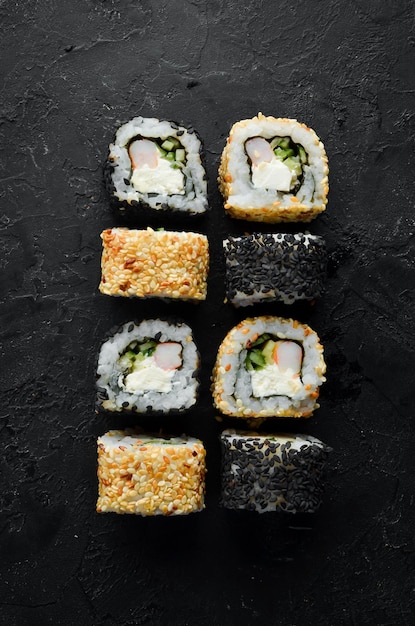 Sushi tradizionale in bianco e nero con formaggio di granchio ed erbe aromatiche Cucina giapponese Vista dall'alto