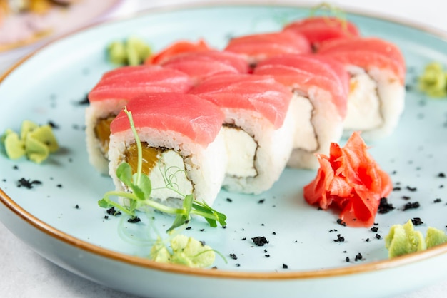 Sushi uramaki su un piatto azzurro da vicino