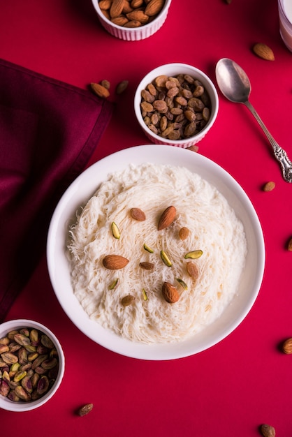 Sutarfeni dolce indiano o sutar feni o firni o seviyan o laccha, farina di riso a scaglie sminuzzata arrostita nel burro chiarificato, mescolata con zucchero fuso per formare uno zucchero filato, condita con pistacchio e mandorle