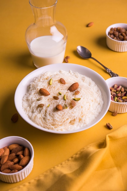 Sutarfeni dolce indiano o sutar feni o firni o seviyan o laccha, farina di riso a scaglie sminuzzata arrostita nel burro chiarificato, mescolata con zucchero fuso per formare uno zucchero filato, condita con pistacchio e mandorle