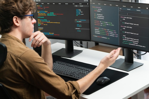 sviluppatore IT che lavora online sviluppo software codifica su schermi PC Gusher
