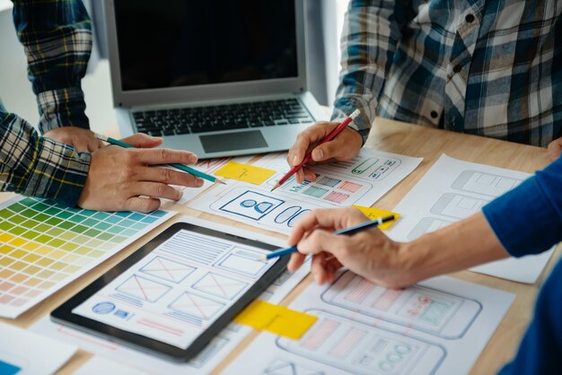 Sviluppatore UX e designer UI brainstorming sulla progettazione di wireframe dell'interfaccia dell'app mobile con breif del cliente e codice colore presso modern officexA