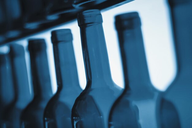 Svuotare i colli delle bottiglie di vino in fila come illustrazione di abbuffate o problemi di alcolismo e depressione causati dalla dipendenza da alcol