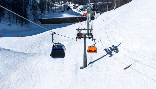 Svuotare la seggiovia da sci arancione brillante in montagna inverno contro la neve Sci alpino e snowboard