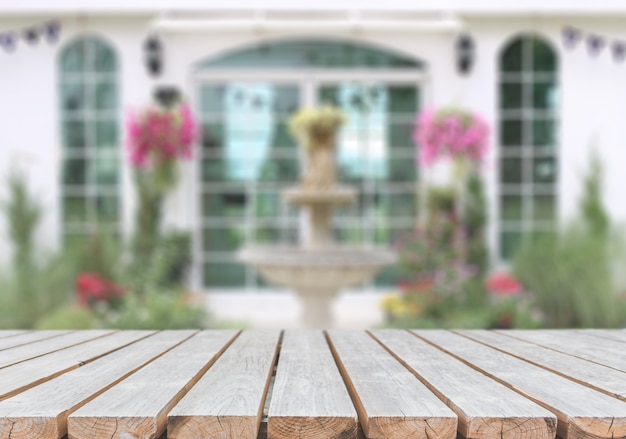 Svuoti il ​​piano d&#39;appoggio di legno ed il fondo vago del giardino e della casa.