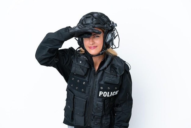 SWAT donna caucasica isolata su sfondo bianco che guarda lontano con la mano per guardare qualcosa