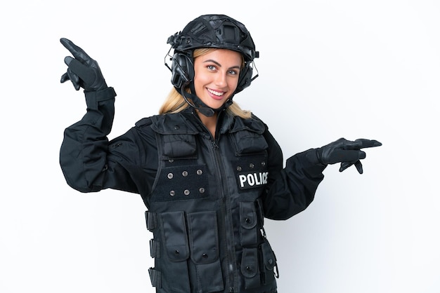 SWAT donna caucasica isolata su sfondo bianco che punta il dito verso i laterali e felice