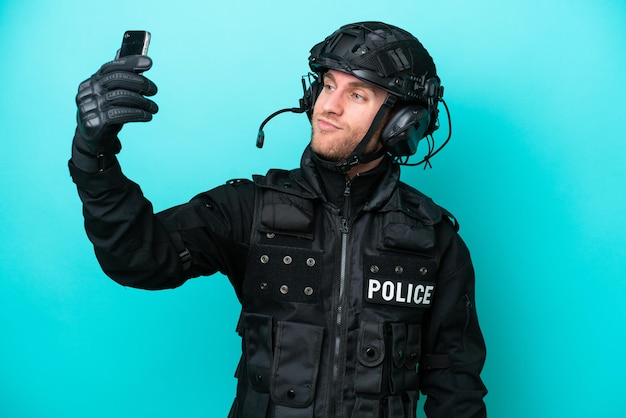 SWAT uomo caucasico isolato su sfondo blu facendo un selfie