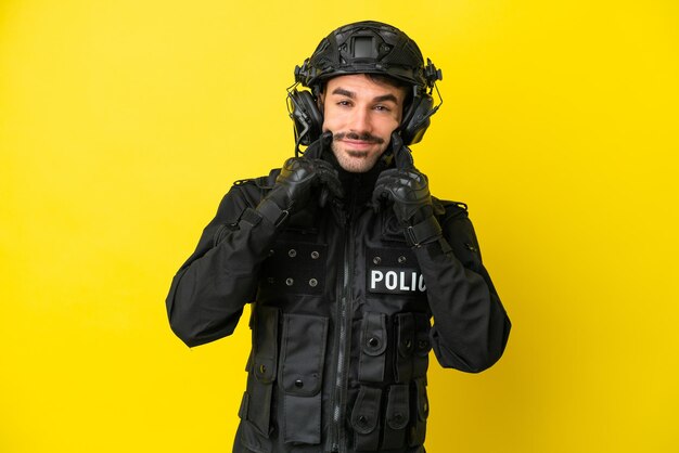 SWAT uomo caucasico isolato su sfondo giallo sorridente con un'espressione felice e piacevole