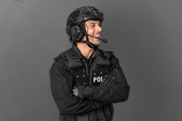SWAT uomo caucasico isolato su sfondo grigio felice e sorridente
