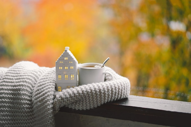 Sweet Home Natura morta dettagli in casa su una finestra di legno Maglione tè caldo e arredamento autunnale Arredamento per la casa autunnale Accogliente atmosfera autunnale Ringraziamento Halloween Accogliente concetto autunnale o invernale