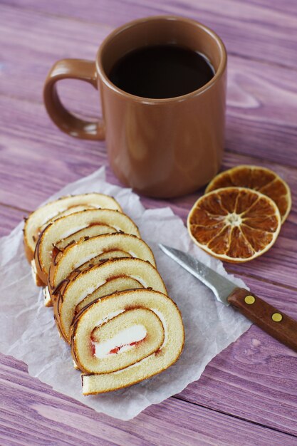 Swiss roll affettato con inceppamento su un fondo rosa di legno