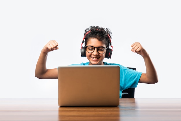 Syudent maschio indiano o bambino che studia online utilizzando il computer portatile. Bambino asiatico che frequenta la scuola online usando il computer