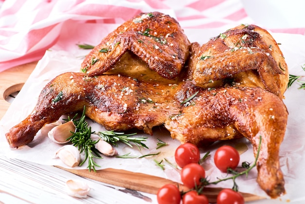 Tabacco di pollo alla griglia su carta su sfondo bianco in legno