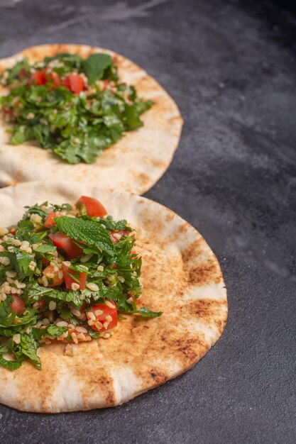 Tabbouleh, tradizionale piatto mediorientale o arabo, sul pane pita. Solitamente preparato con prezzemolo, menta, bulgur, pomodoro