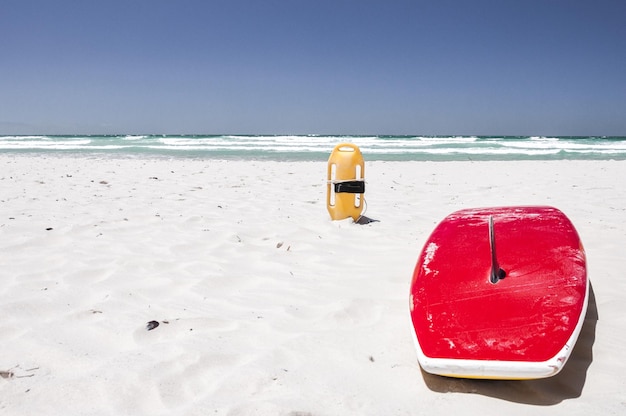 Tabella da surf sulla spiaggia contro un cielo limpido