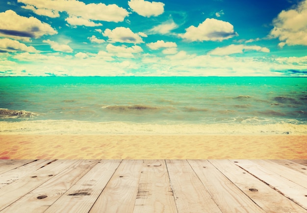 Tabella di legno sabbia spiaggia e mare in nuvole cielo con tono d&#39;epoca.