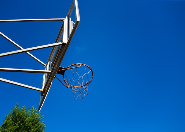 Tabellone da basket con un anello per strada nel parco giochi sullo sfondo del cielo