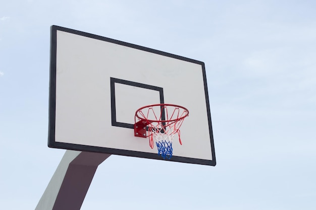 Tabellone di pallacanestro contro la vista laterale del fondo del cielo blu