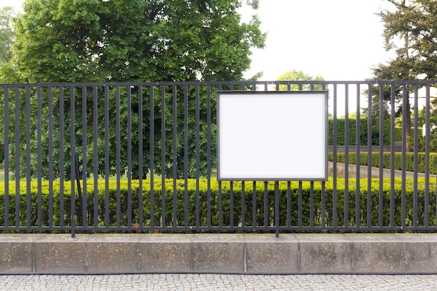 Tabellone per le affissioni in bianco mock up in un giardino pubblico