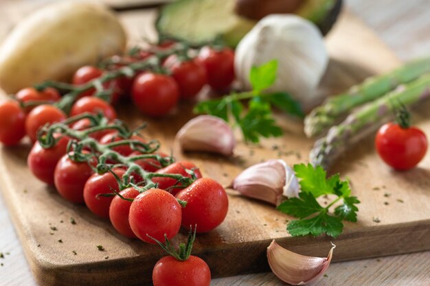 Tabla con ingredienti como pomodori cherry ajo esparragos patata y aguacate