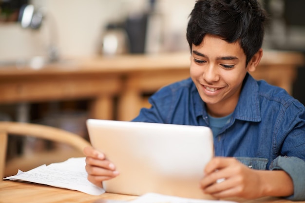 Tablet della scuola e ragazzo in classe con il sorriso che impara il sito internet e i giovani studenti Educazione digitale elearning e bambino nella classe Montessori felicità e studio con la lettura online