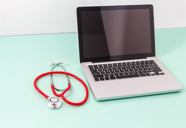 Tablet e stetoscopio su una scrivania verde chiaro Concetto di tecnologia della comunicazione e medicina