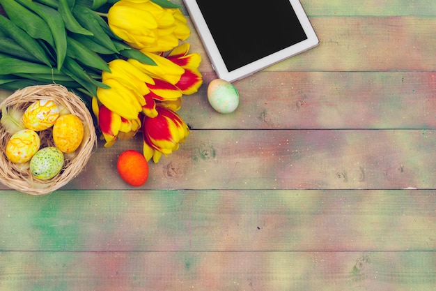 Tablet, fiori di tulipano colorati e uovo di Pasqua