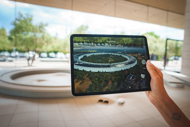 Tablet in mano con la navicella spaziale di Apple Park sullo schermo Cupertino California