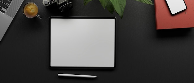 Tablet mockup schermo vuoto per visualizzare la tua grafica su sfondo nero sul posto di lavoro con forniture