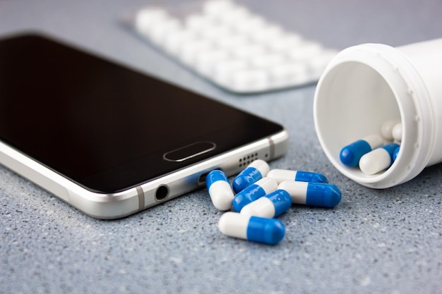 Tablet vicino a uno smartphone Capsule mediche medicinali e uno smartphone Acquisto online di medicinali in farmacia