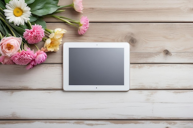 Tabletta in primo piano con un monitor a schermo vuoto con un bouquet di fiori sullo sfondo bianco del tavolo