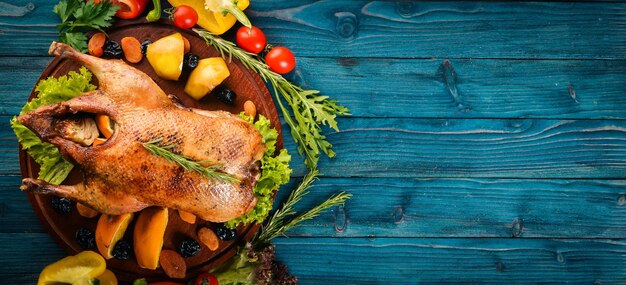 Tacchino al forno con verdure e spezie Giorno del Ringraziamento Griglia di pollo d'oca su sfondo di legno Vista dall'alto