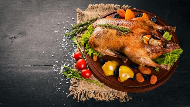 Tacchino al forno con verdure e spezie Giorno del Ringraziamento Griglia di pollo d'oca su sfondo di legno Vista dall'alto