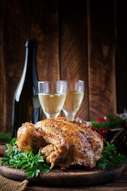 Tacchino o pollo al forno. La tavola di Natale è servita con un tacchino, decorato con orpelli luminosi. Pollo fritto, tavola. Cena di Natale.