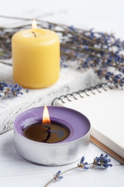 Taccuino aperto vuoto con fiori di lavanda secchi e candele