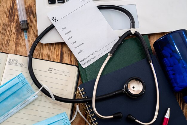 Taccuino bianco con prescrizione dello stetoscopio dal medico sulla tastiera nera con maschere per notebook sul tavolo. Concetto di medicina