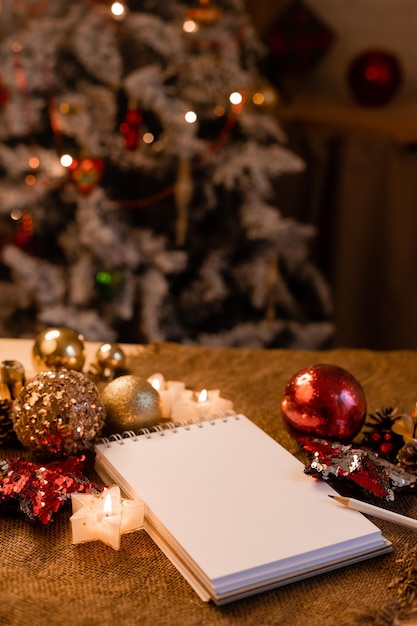 Taccuino con pagine vuote su un tavolo di legno in cucina sullo sfondo di un natale